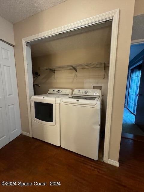 washroom with dark hardwood / wood-style floors, separate washer and dryer, and a textured ceiling