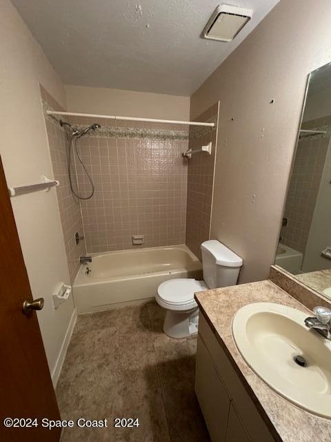 full bathroom with tiled shower / bath, vanity, and toilet