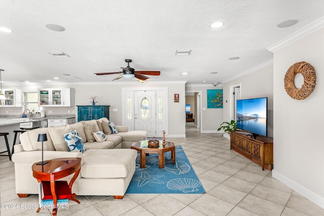 living room with ornamental molding, ceiling fan, light tile patterned flooring, and a textured ceiling