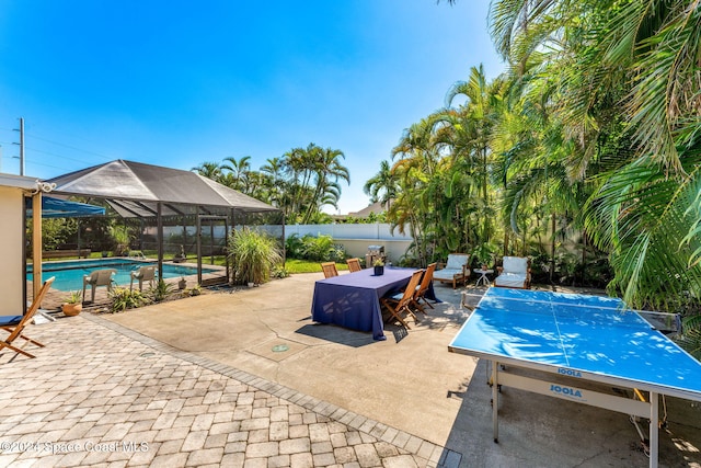 view of pool featuring glass enclosure and a patio area