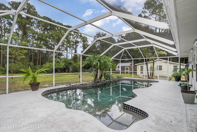 view of pool with a yard, a patio area, a lanai, and an outdoor structure