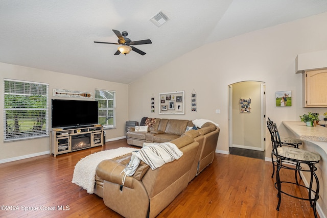 living room featuring ceiling fan, wood-type flooring, and lofted ceiling