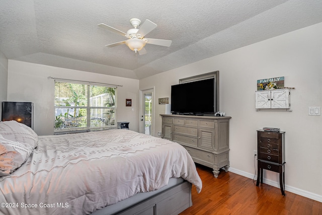 bedroom featuring ceiling fan, a textured ceiling, dark hardwood / wood-style flooring, and vaulted ceiling