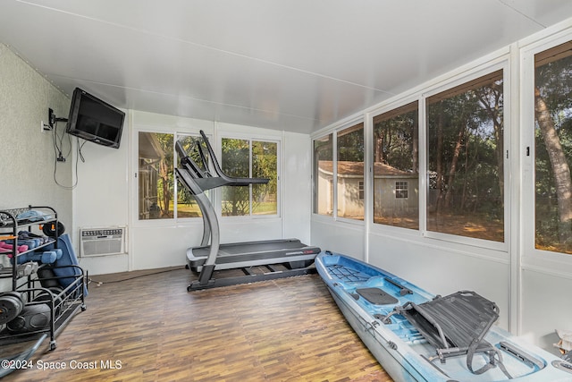 workout area with an AC wall unit and hardwood / wood-style flooring