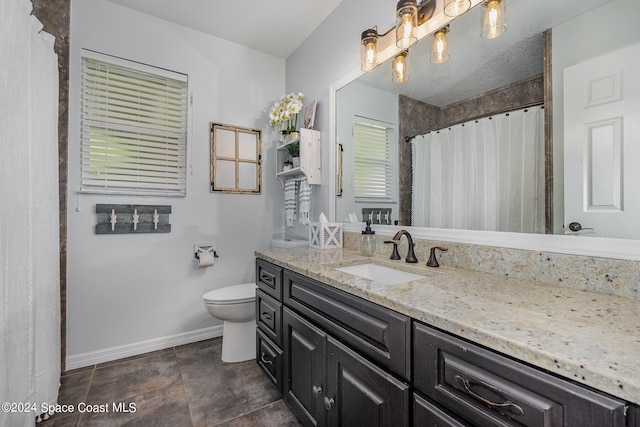 bathroom featuring vanity, a textured ceiling, and toilet