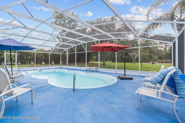 view of pool with a patio area, a lawn, and glass enclosure