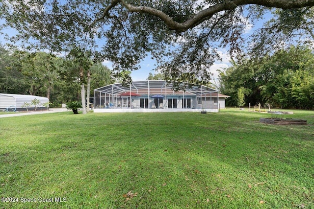 exterior space featuring a yard and glass enclosure