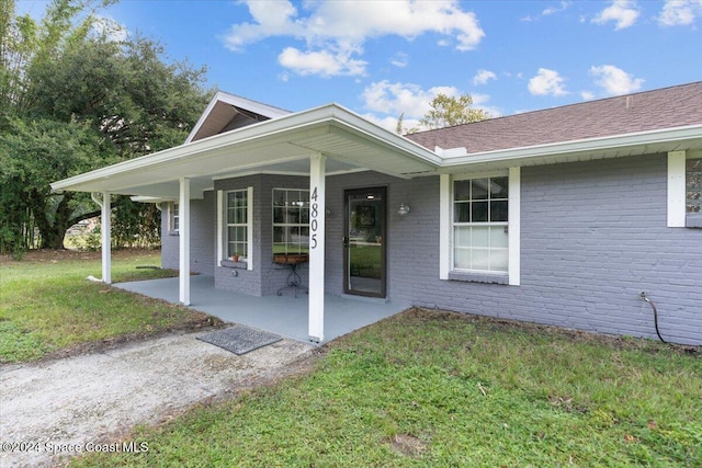 view of exterior entry featuring a yard