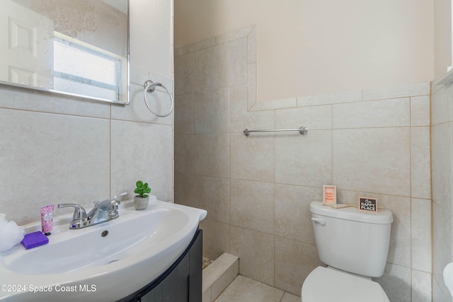 bathroom featuring tile walls, vanity, and toilet