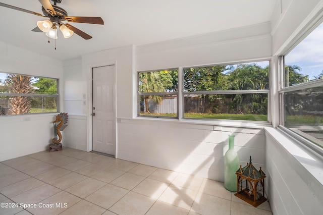 unfurnished sunroom with ceiling fan