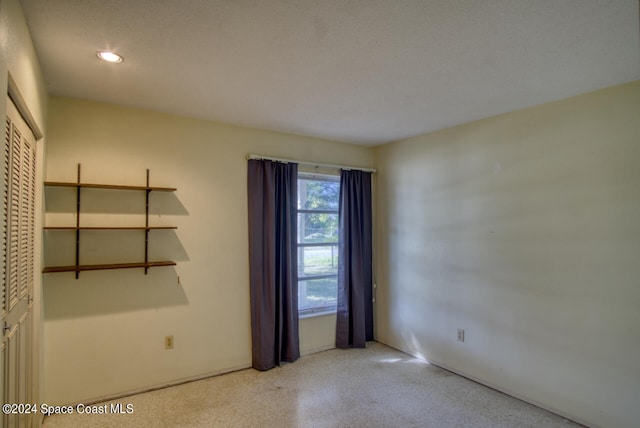 unfurnished room with a textured ceiling