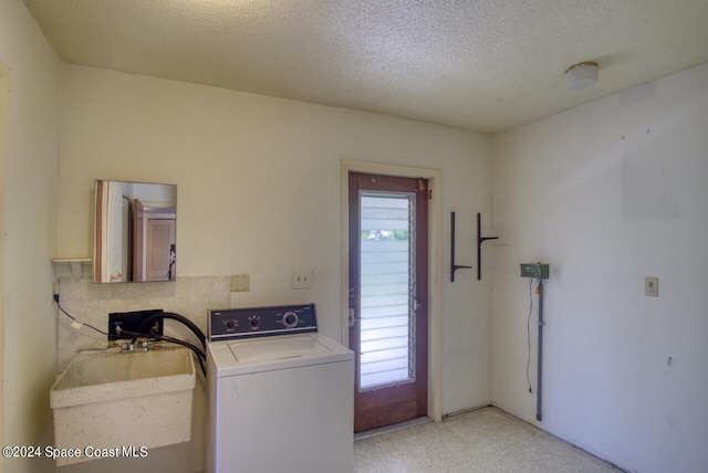 washroom featuring sink, a textured ceiling, and washer / clothes dryer