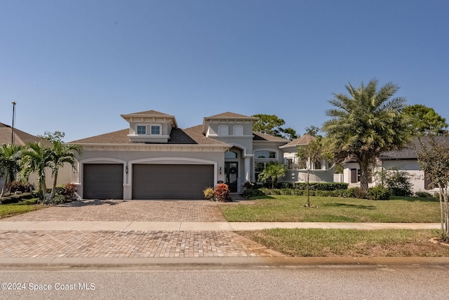 view of front of home with a front yard and a garage