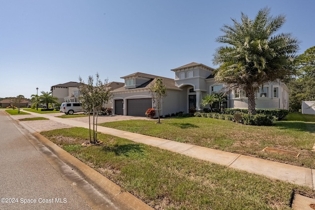 mediterranean / spanish home featuring a front yard and a garage