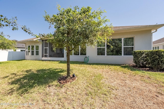 back of house featuring a yard and a sunroom