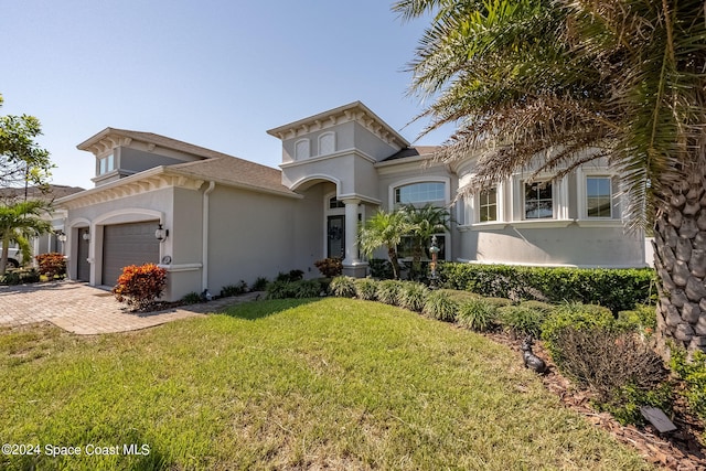 mediterranean / spanish-style home featuring a front yard and a garage