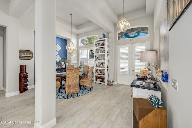 office space with a raised ceiling, a chandelier, and light hardwood / wood-style floors