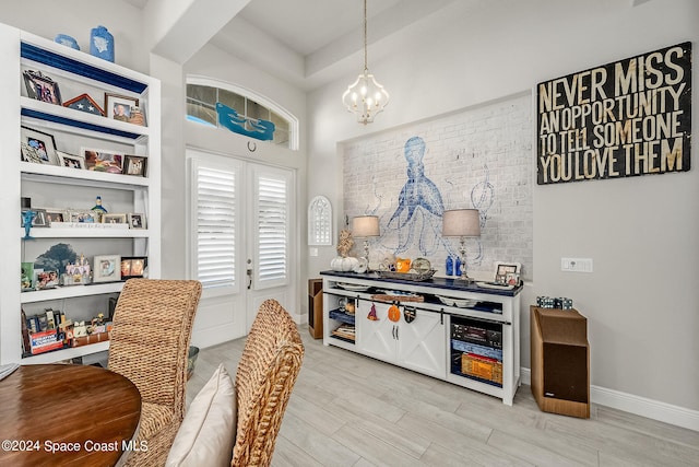 interior space with pendant lighting, an inviting chandelier, and light hardwood / wood-style flooring