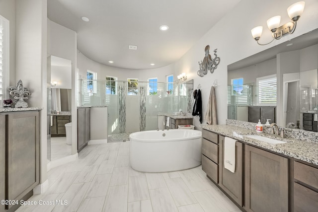 bathroom with vanity and shower with separate bathtub