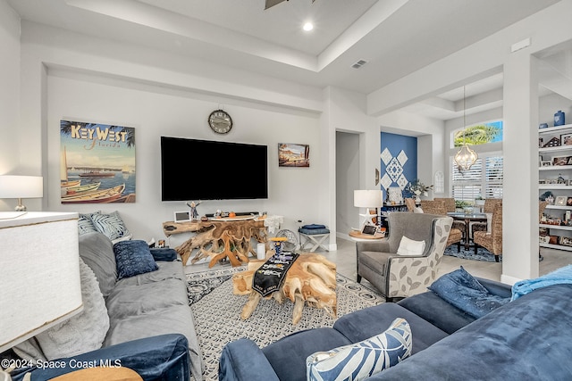 living room featuring a tray ceiling and an inviting chandelier