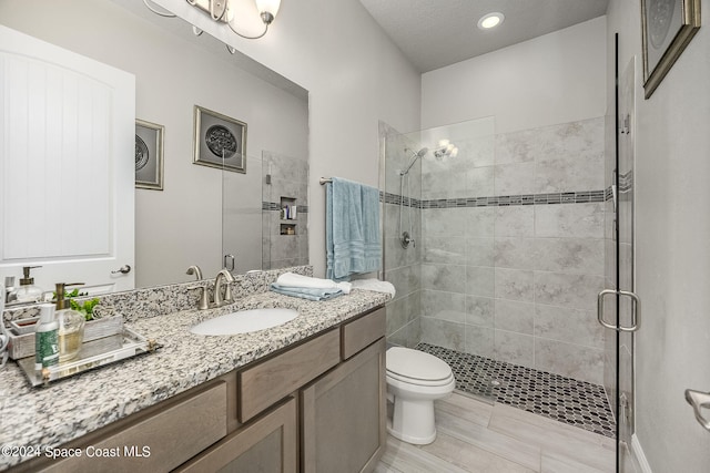 bathroom featuring walk in shower, vanity, and toilet