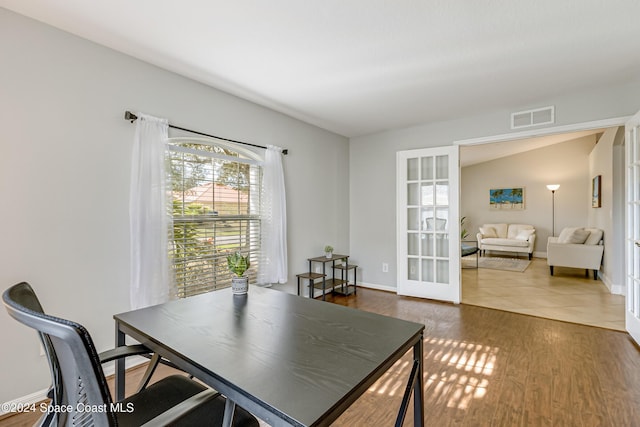 office with vaulted ceiling, dark wood-type flooring, and french doors