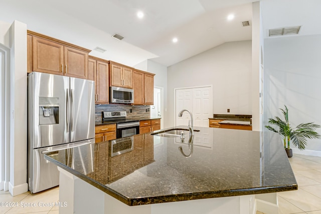 kitchen featuring a large island, appliances with stainless steel finishes, and vaulted ceiling