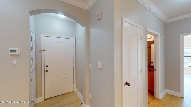 hallway featuring crown molding and light wood-type flooring