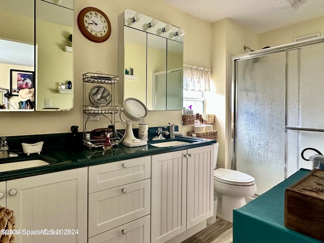 bathroom with an enclosed shower, hardwood / wood-style floors, vanity, and toilet