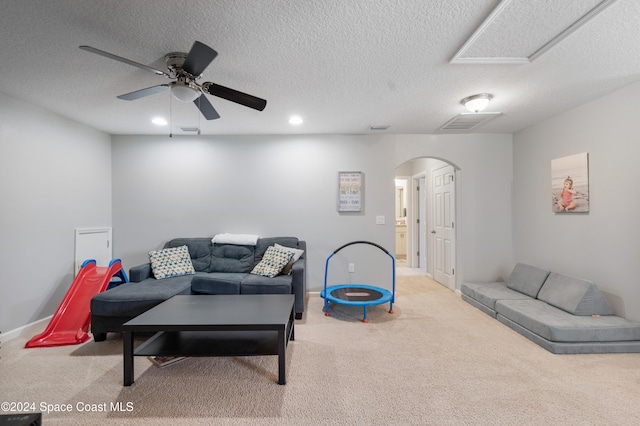 carpeted living room with a textured ceiling and ceiling fan