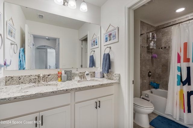 full bathroom featuring vanity, shower / bath combo, and toilet