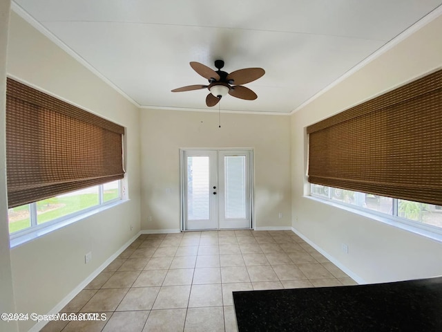 tiled entrance foyer featuring ceiling fan, crown molding, plenty of natural light, and french doors