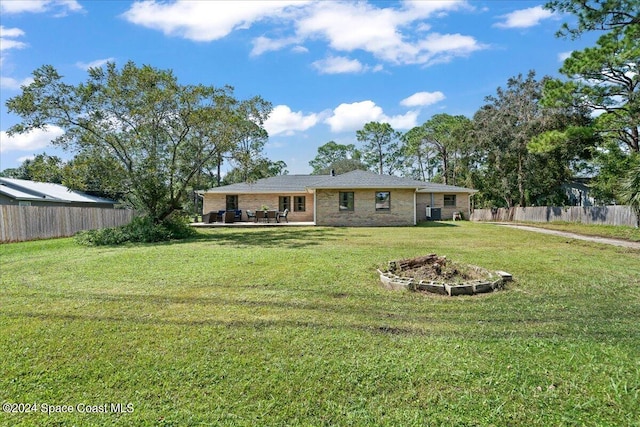 rear view of property featuring a patio area and a lawn