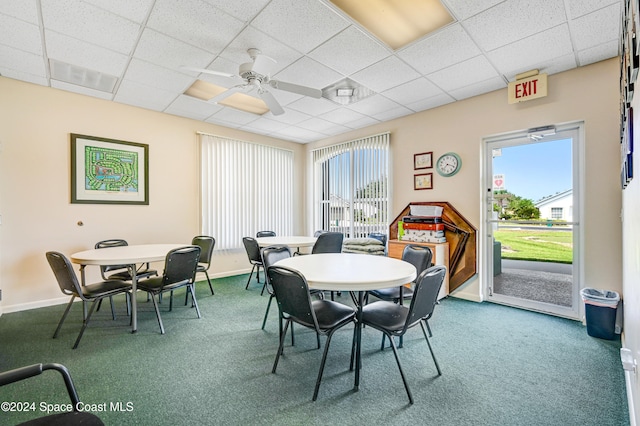 carpeted dining room featuring a paneled ceiling, ceiling fan, and plenty of natural light