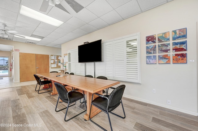 dining room with a drop ceiling, ceiling fan, and light hardwood / wood-style flooring