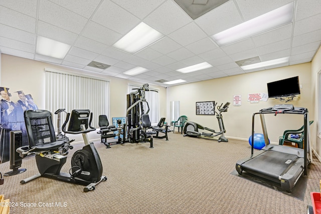 gym featuring carpet flooring and a paneled ceiling