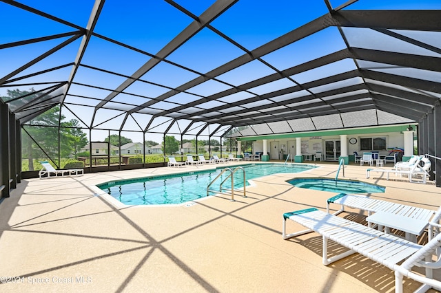 view of pool with a patio area, a lanai, and an in ground hot tub