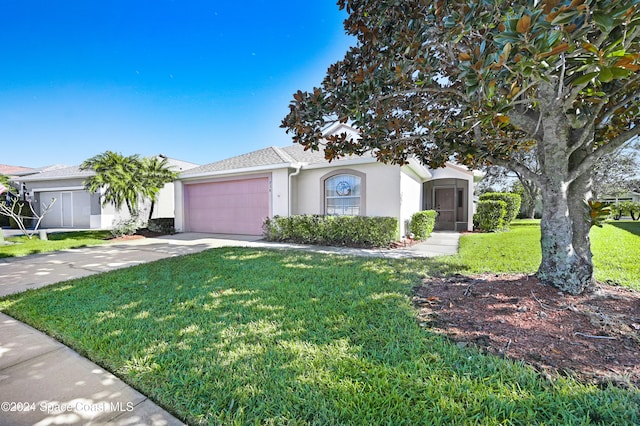 view of front of house with a garage and a front lawn