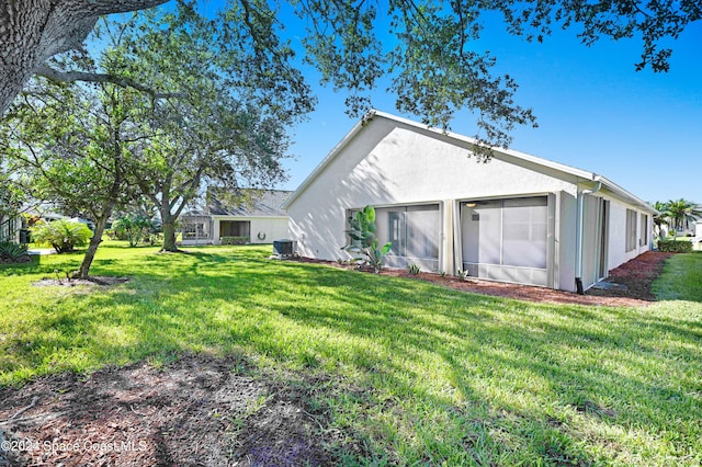 back of house featuring a yard and central AC unit