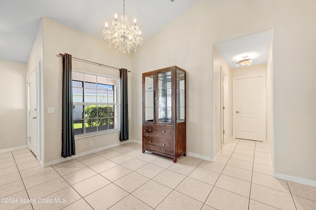 foyer with light tile patterned floors, a chandelier, and vaulted ceiling