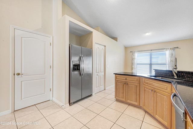 kitchen with light tile patterned flooring, sink, lofted ceiling, and stainless steel appliances