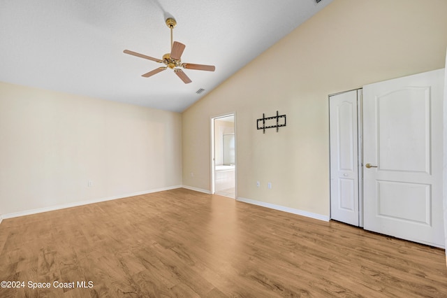 spare room with light wood-type flooring, high vaulted ceiling, and ceiling fan