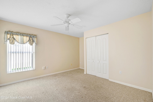 unfurnished bedroom with carpet flooring, a closet, and ceiling fan