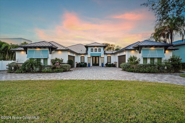 view of front of house featuring a garage and a lawn