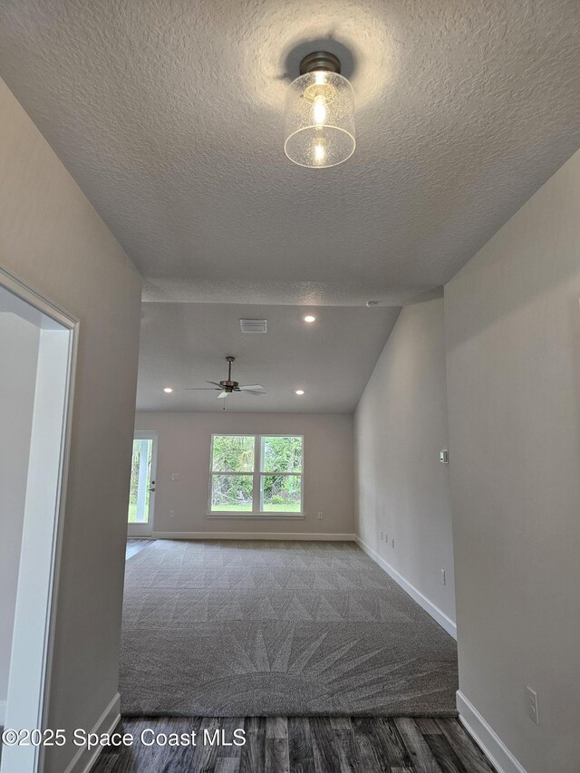 713 Degroodt Rd SW, Palm Bay, FL 32908 - spare room featuring wood finished floors, baseboards, a textured ceiling, a ceiling fan, and carpet