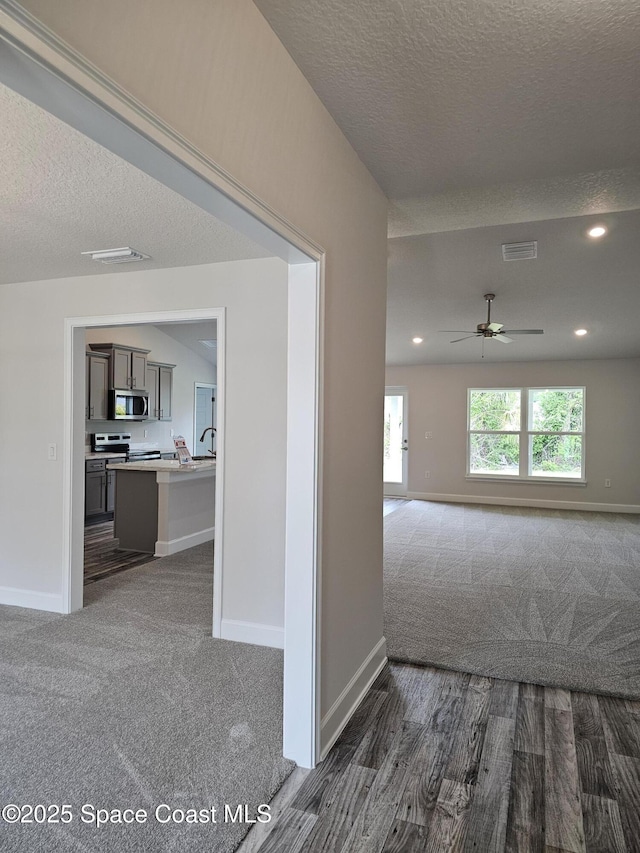 713 Degroodt Rd SW, Palm Bay, FL 32908 - corridor with dark colored carpet, a textured ceiling, baseboards, and recessed lighting