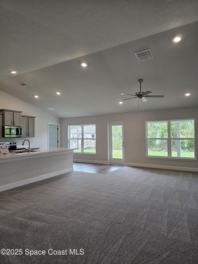 713 Degroodt Rd SW, Palm Bay, FL 32908 - unfurnished living room with carpet flooring, recessed lighting, baseboards, lofted ceiling, and ceiling fan