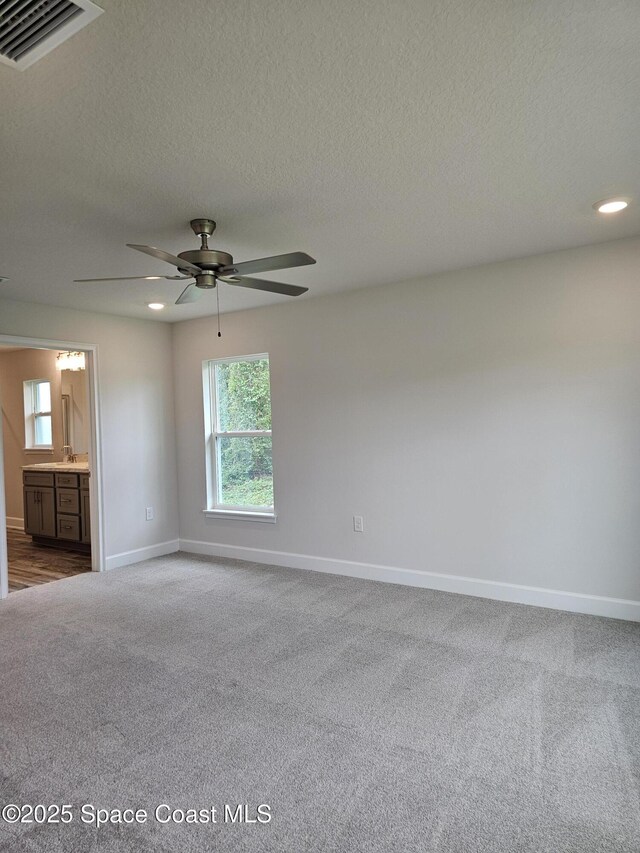 713 Degroodt Rd SW, Palm Bay, FL 32908 - empty room with dark colored carpet, baseboards, a ceiling fan, a textured ceiling, and recessed lighting