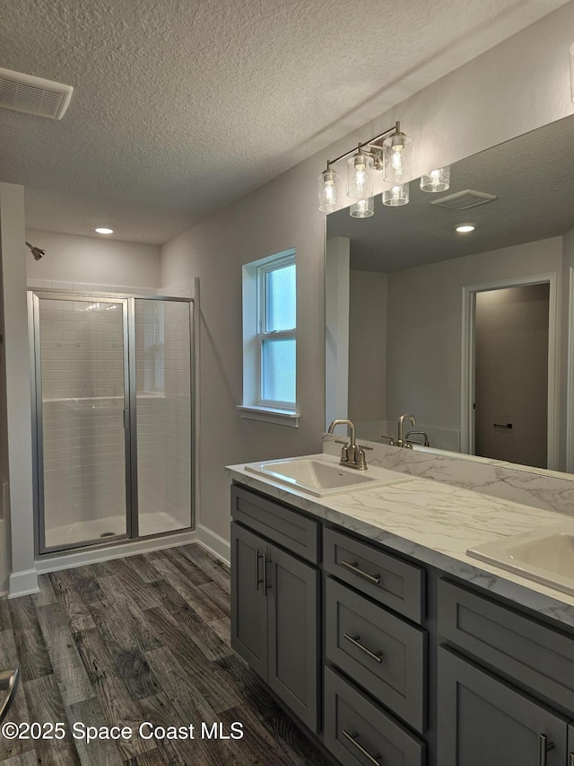 713 Degroodt Rd SW, Palm Bay, FL 32908 - full bath with a stall shower, double vanity, wood finished floors, a textured ceiling, and recessed lighting