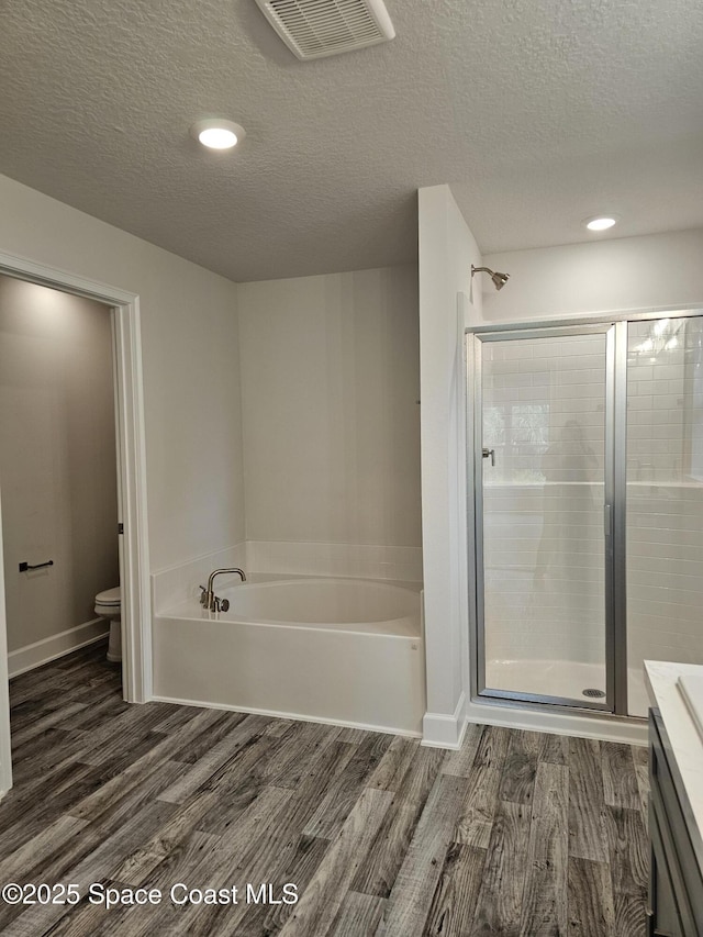713 Degroodt Rd SW, Palm Bay, FL 32908 - bathroom featuring a bath, wood finished floors, toilet, a textured ceiling, and vanity